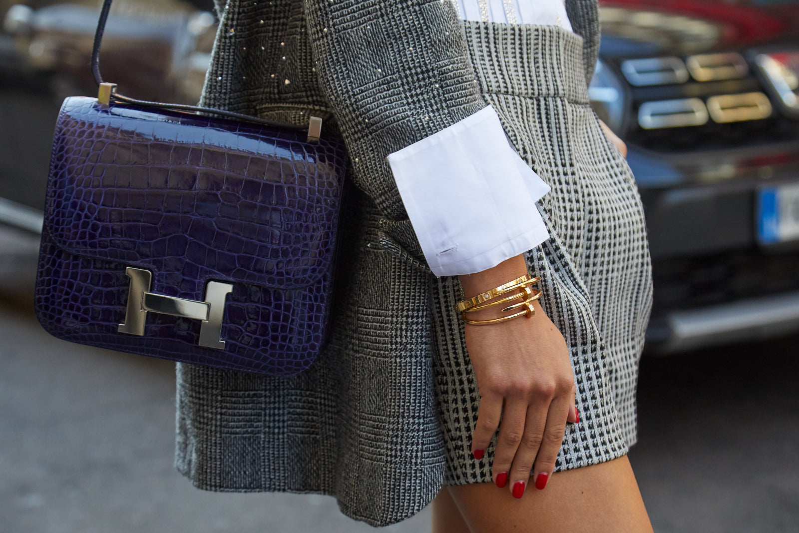 Close-up street style image of tailored outfit and structured Hermès handbag with iconic hardware.